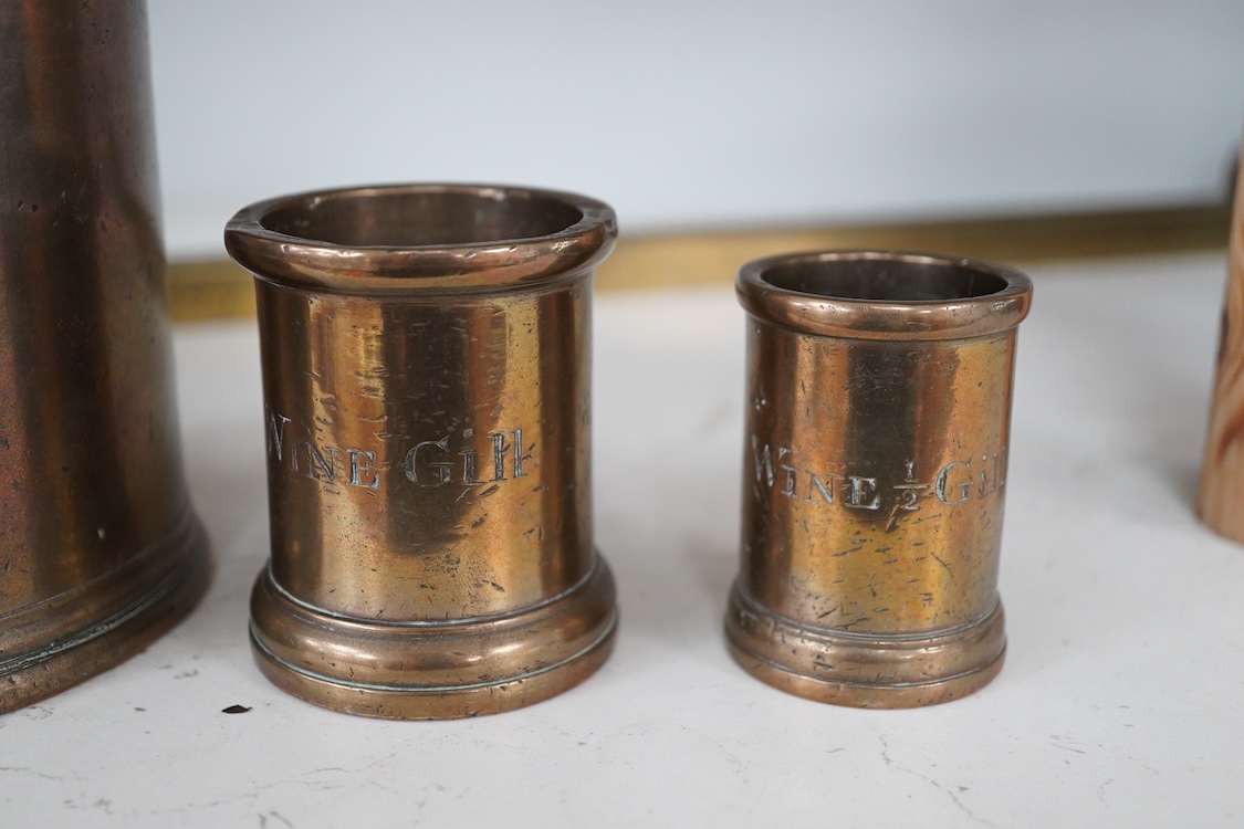 Three 19th century bell metal wine gill measures, two smaller examples engraved; ‘wine hill’, tallest 13.5cm